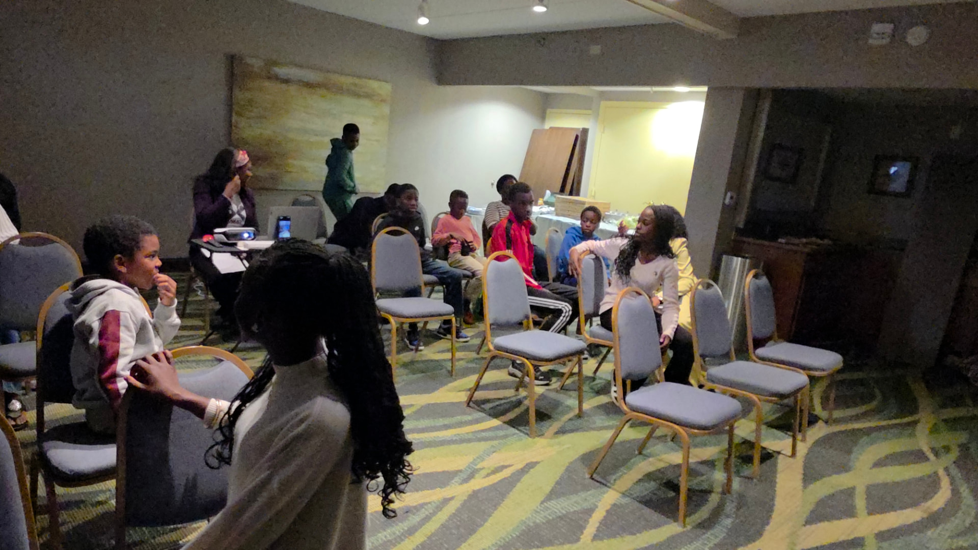 A NEXT Academy group session with teens seated together and a mentor leading