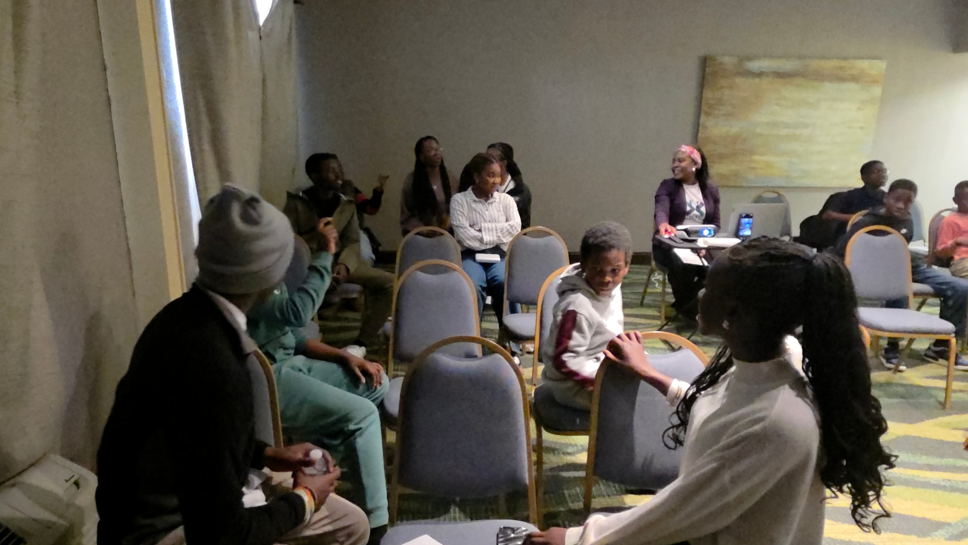 Teens and mentors chatting during a NEXT Academy session in a circle of chairs