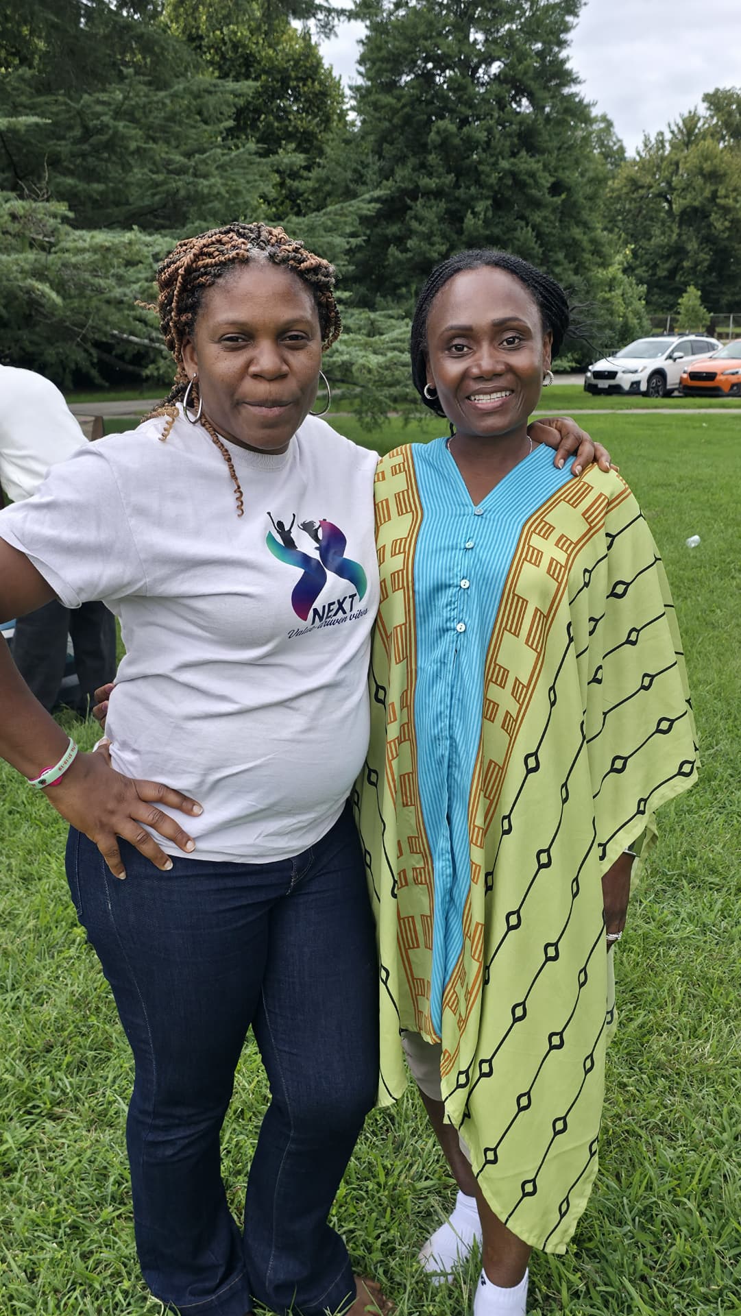 Two NEXT Academy mentors smiling together outdoors on the grass